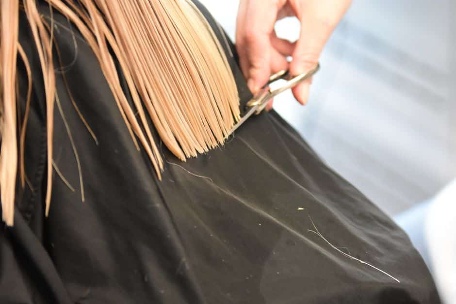 Coiffeur réalisant une coupe en salon