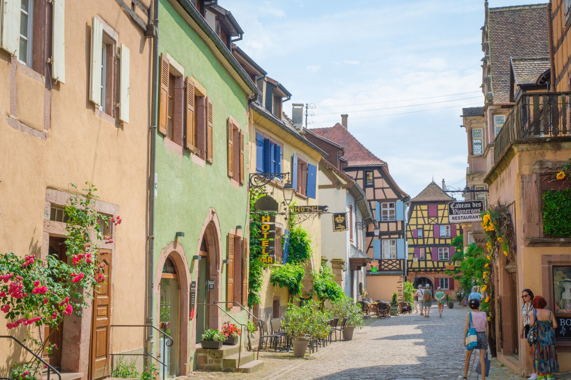Rue pittoresque d'un village alsacien aux façades colorées, destination touristique française
