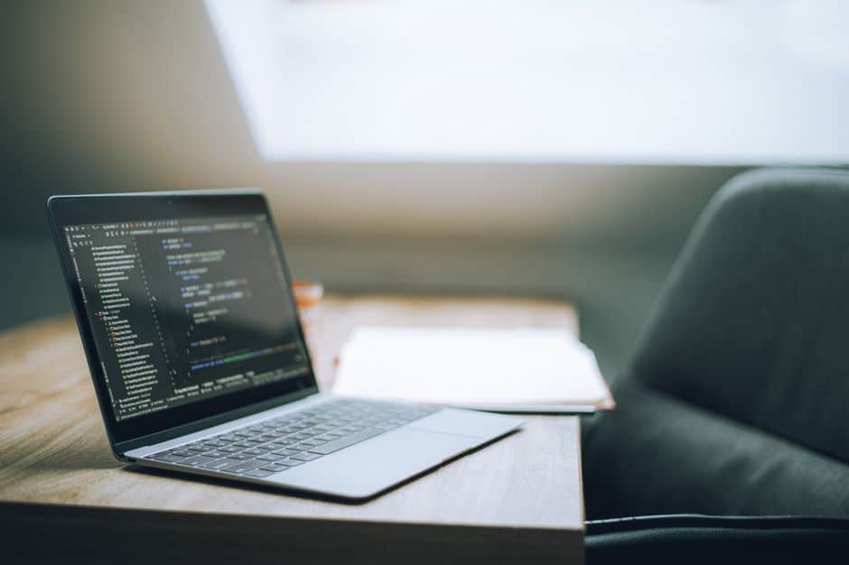 Ordinateur portable affichant du code dans un espace de travail lumineux